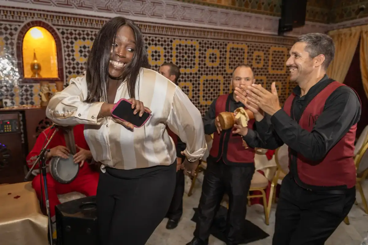 Invitée dansant avec les musiciens pendant un welcome dinner dans la médina de Marrakech